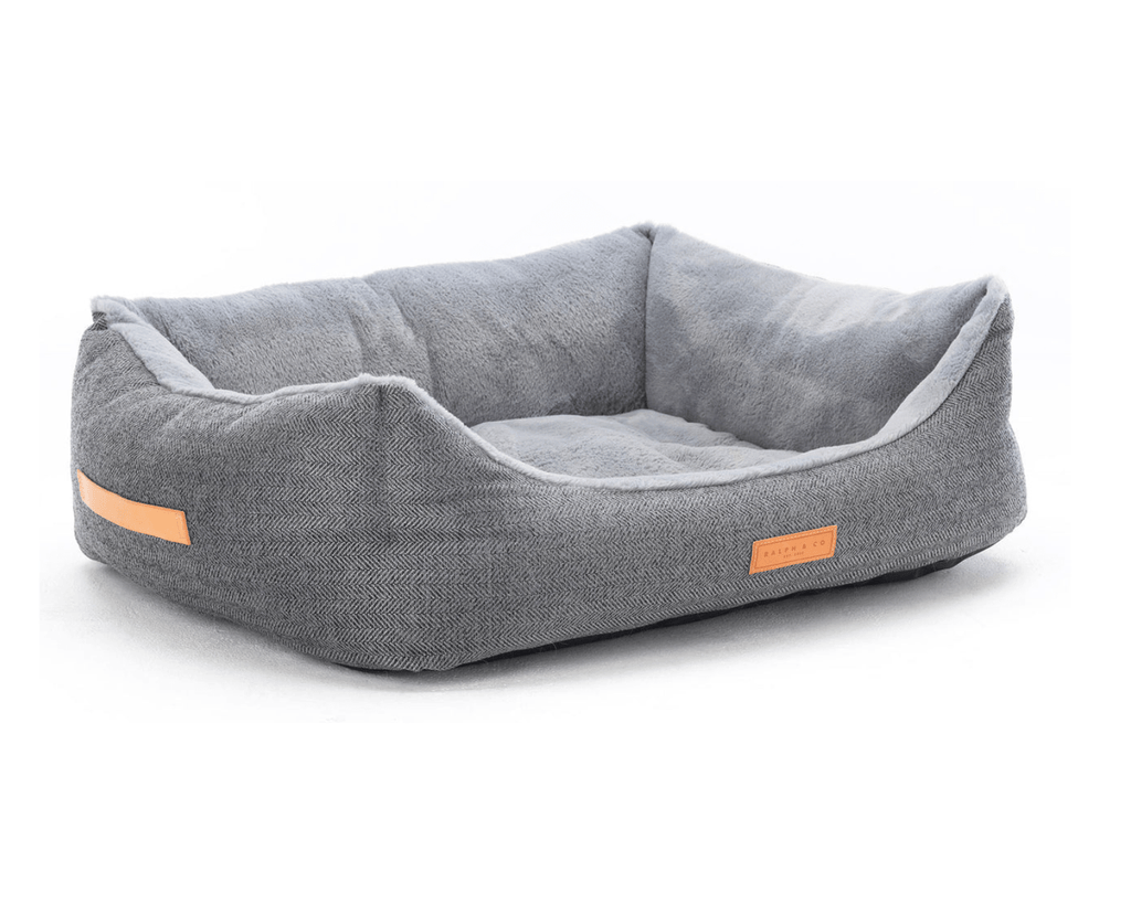 Gray pet bed with orange accents on a white background
