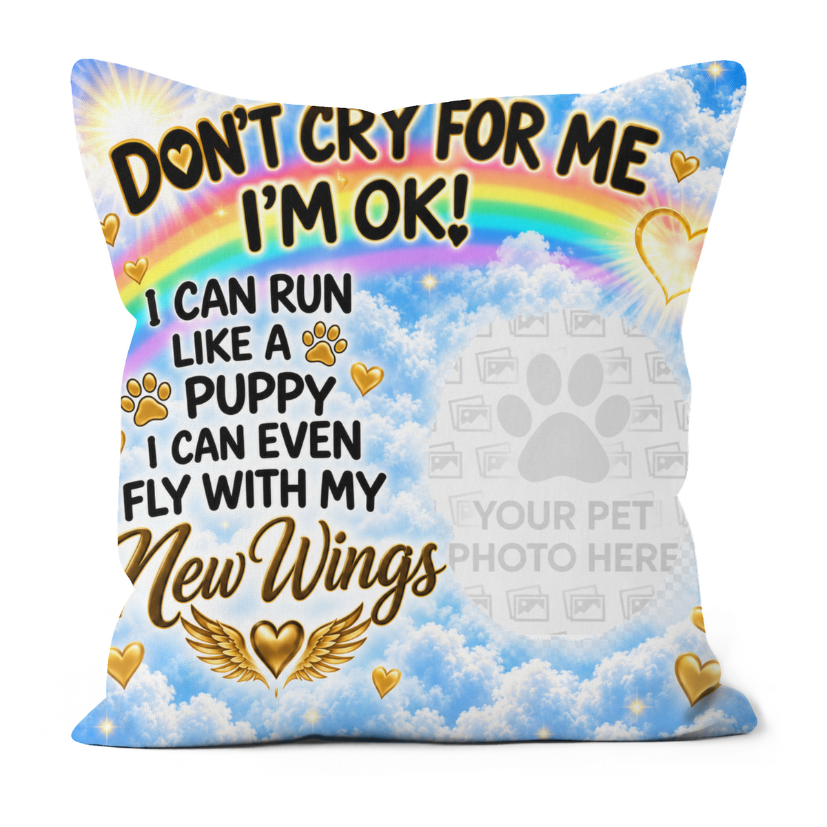 A square decorative throw pillow with a printed pet memorial design. The design features a bright blue sky with white clouds, a rainbow, gold hearts, and the text 'DON'T CRY FOR ME I'M OK! I CAN RUN LIKE A PUPPY I CAN EVEN FLY WITH My New Wings' along with a gray placeholder paw print and 'YOUR PET PHOTO HERE'.