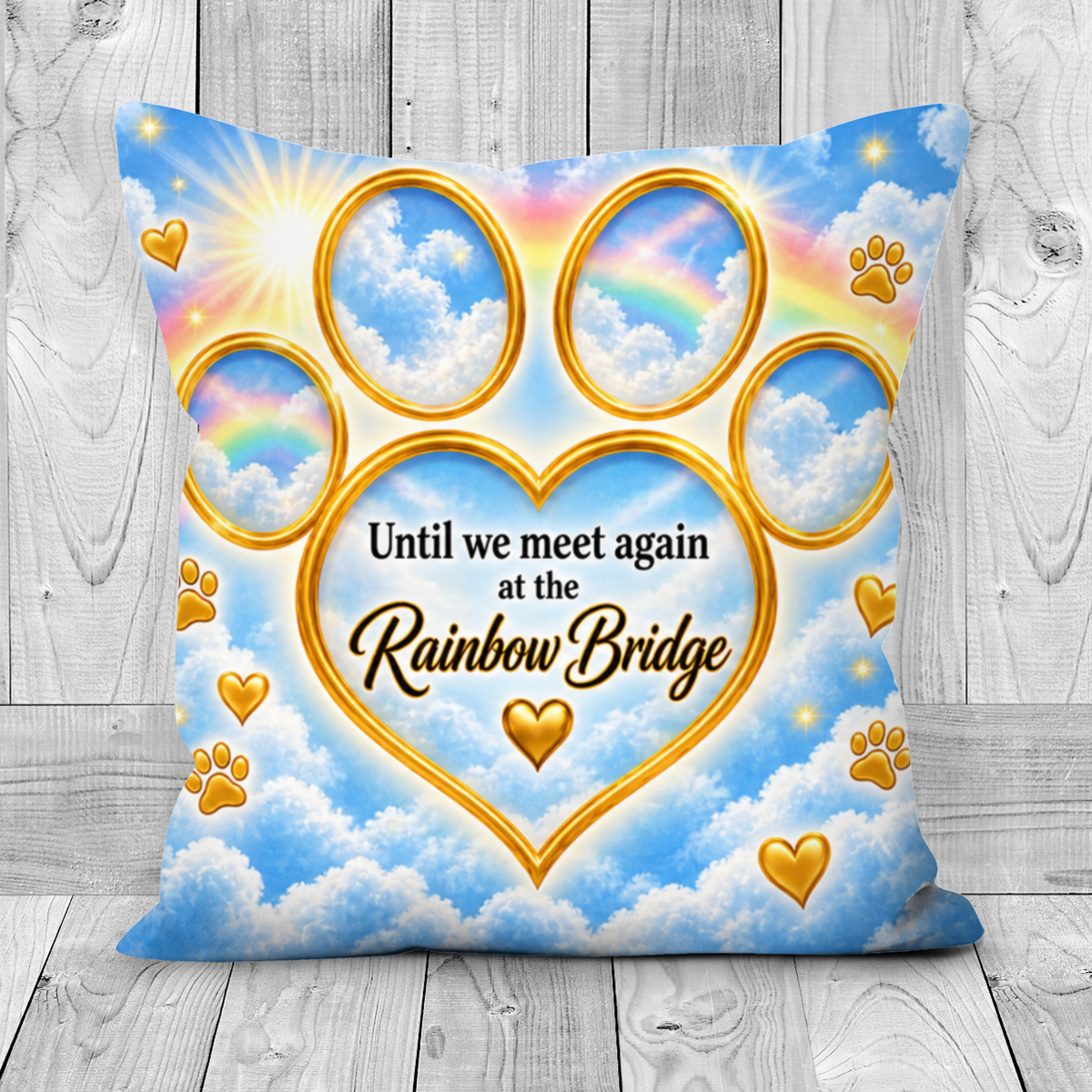 A square pet memorial throw pillow with a printed design of a golden heart and paw print over a blue sky and white clouds background. The text reads 'Until we meet again at the Rainbow Bridge' in gold and black lettering.