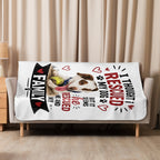 A white fleece throw blanket draped over a light wood sofa in a living room setting. The blanket features a printed graphic
