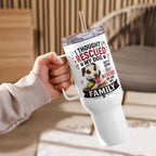 A hand holding a white handled tumbler with a clear lid and straw. The tumbler features a printed design with the text 'I